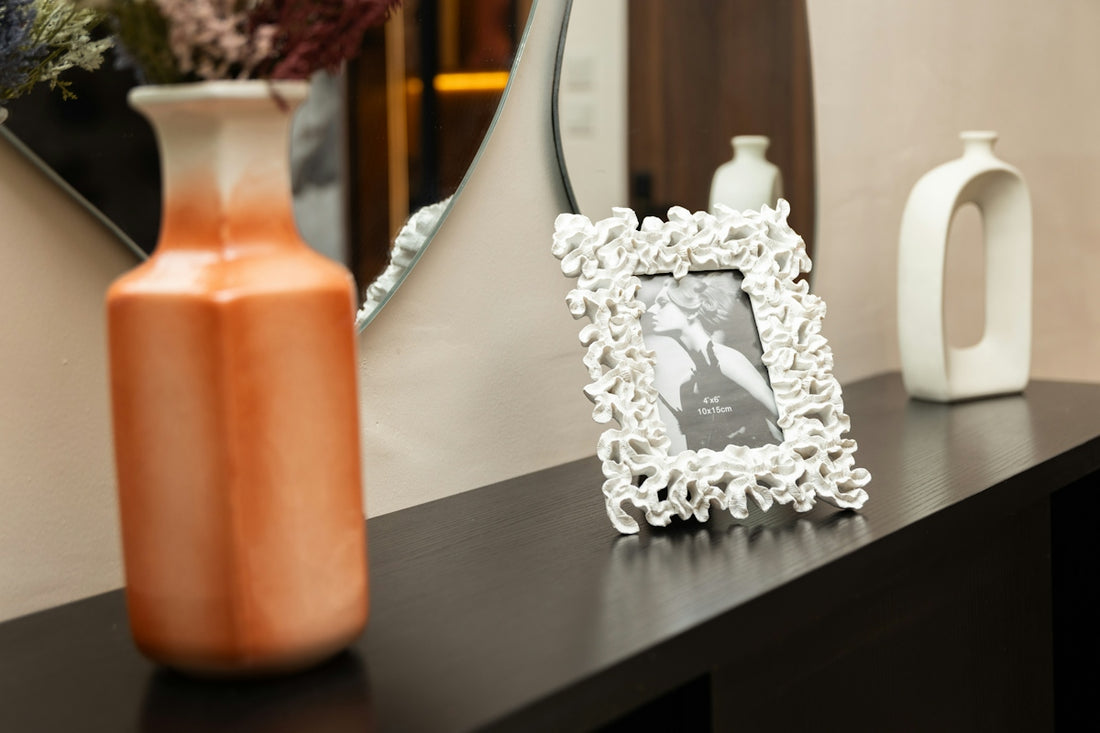 Decorative orange vase, white photo frame, and modern ceramic vase